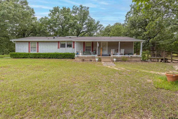 a front view of house with yard and trees in the background