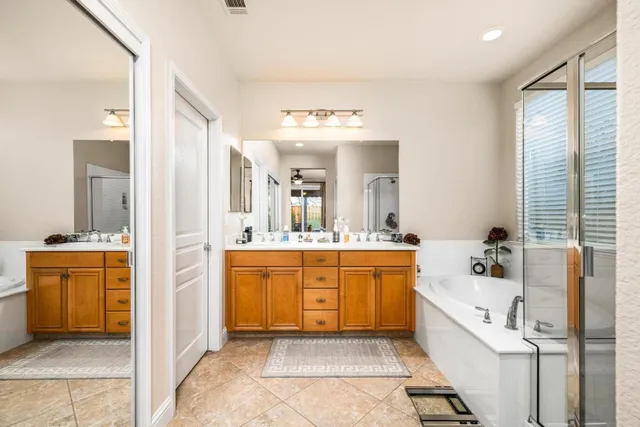 a large bathroom with a large tub sink and mirror