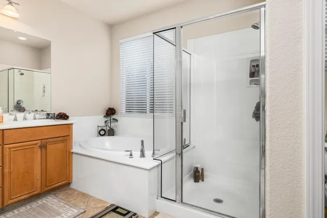 a bathroom with a bathtub shower sink vanity and a toilet