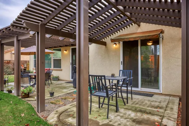 a view of a porch with dining table and chairs with wooden floor and fence
