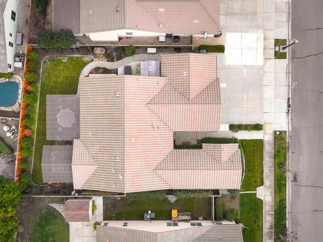 an aerial view of a house with a yard and seating space