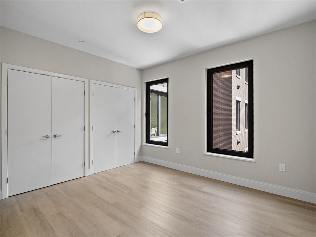 249 Corey Road, Unit 309 Boston, MA 02135 - Photo 20 of 29 a view of an empty room with window and wooden floor