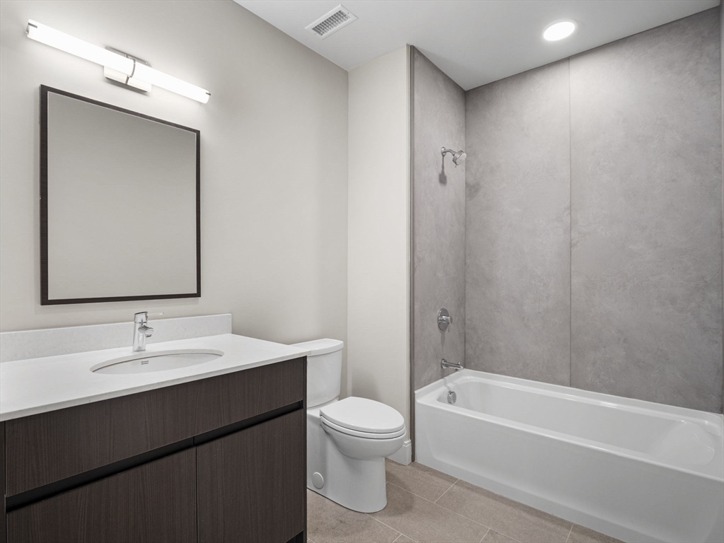 249 Corey Road, Unit 309 Boston, MA 02135 - Photo 23 of 29 a bathroom with a toilet a sink and a bathtub