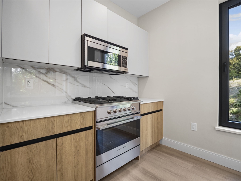 249 Corey Road, Unit 309 Boston, MA 02135 - Photo 5 of 29 a kitchen with a stove and a microwave