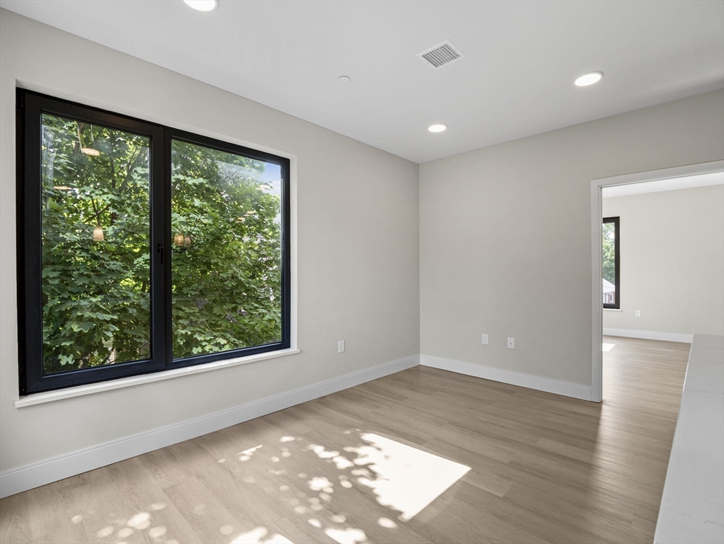 249 Corey Road, Unit 309 Boston, MA 02135 - Photo 10 of 29 a view of empty room with wooden floor and fan