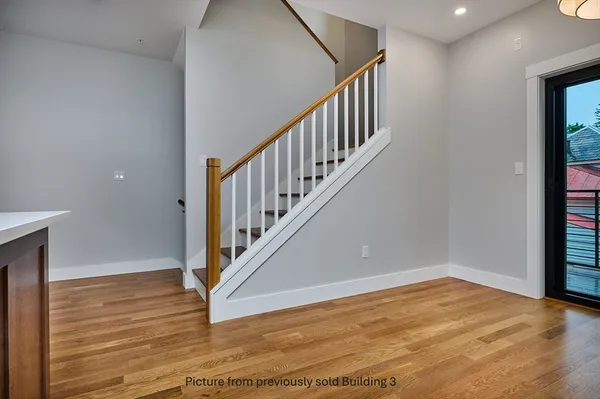 a view of hallway with a large window and wooden floor