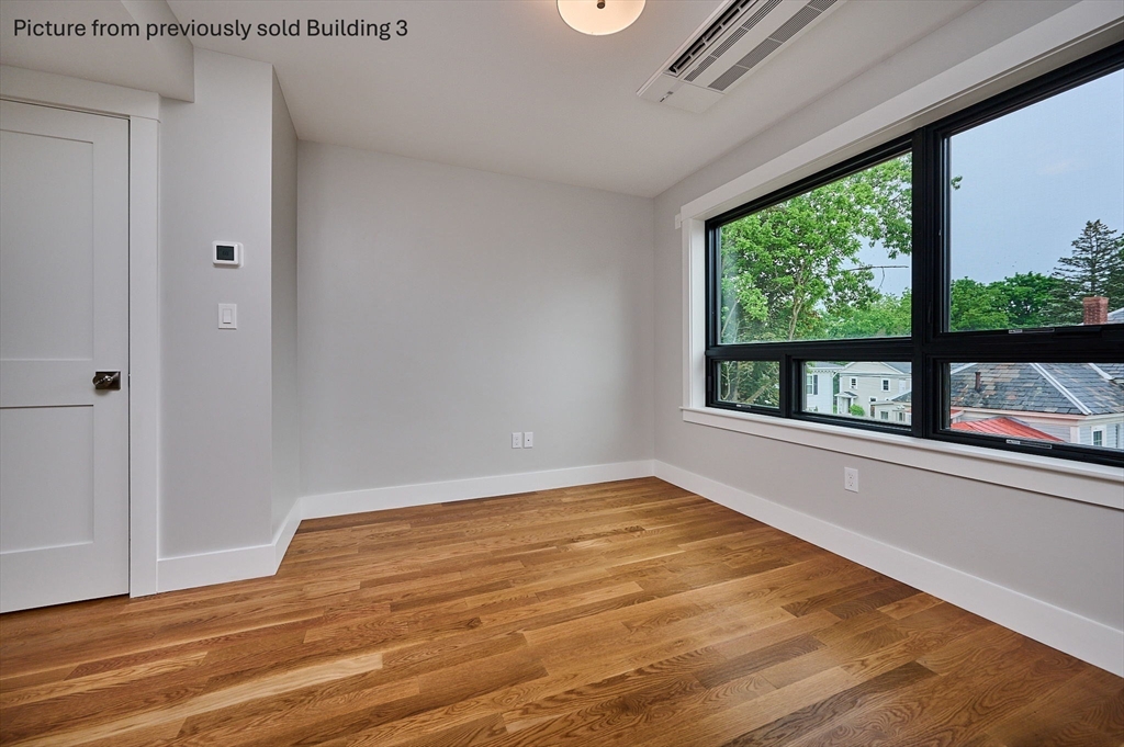 10 Hawley Street, Unit 4D Northampton, MA 01060 - Photo 21 of 22 a view of an empty room with wooden floor and a window