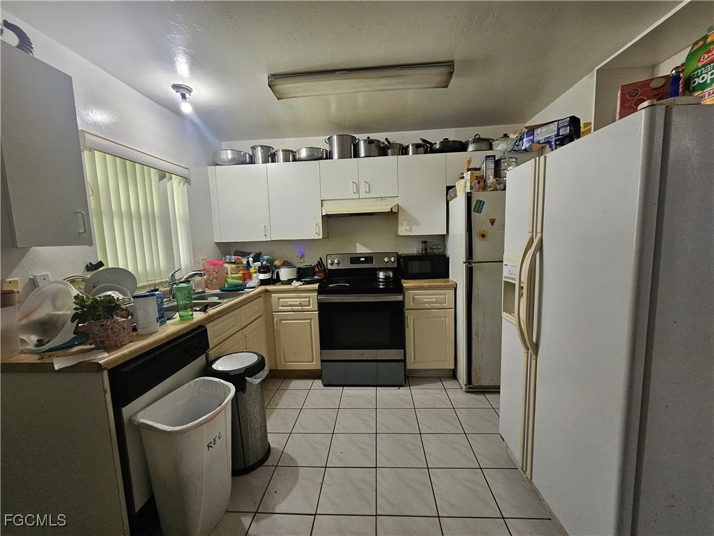2912 Woodside Avenue Naples, FL 34112 - Photo 4 of 16 a kitchen with a refrigerator sink and cabinets