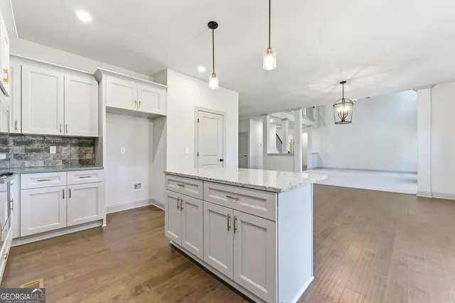 a kitchen with granite countertop white cabinets stainless steel appliances and window