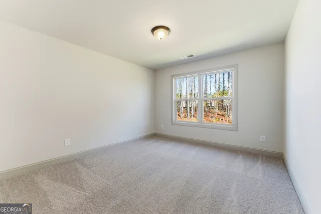 en empty room with ceiling fan and window
