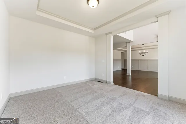 an empty room with a fireplace and a chandelier