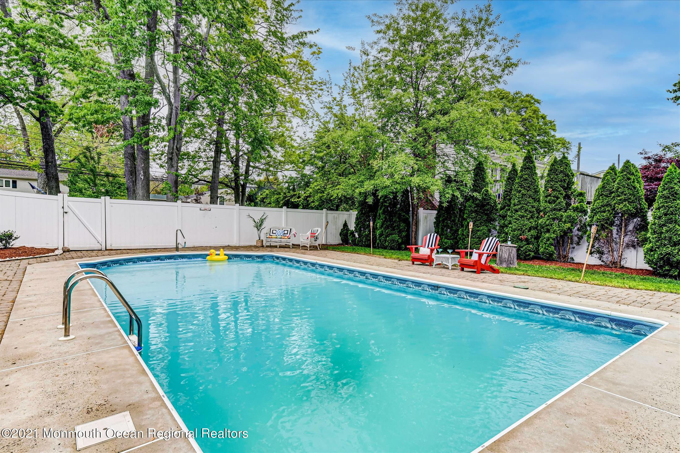675 Harmony Road Middletown, NJ 07748 - Photo 16 of 25 a view of a swimming pool with an outdoor space and seating area