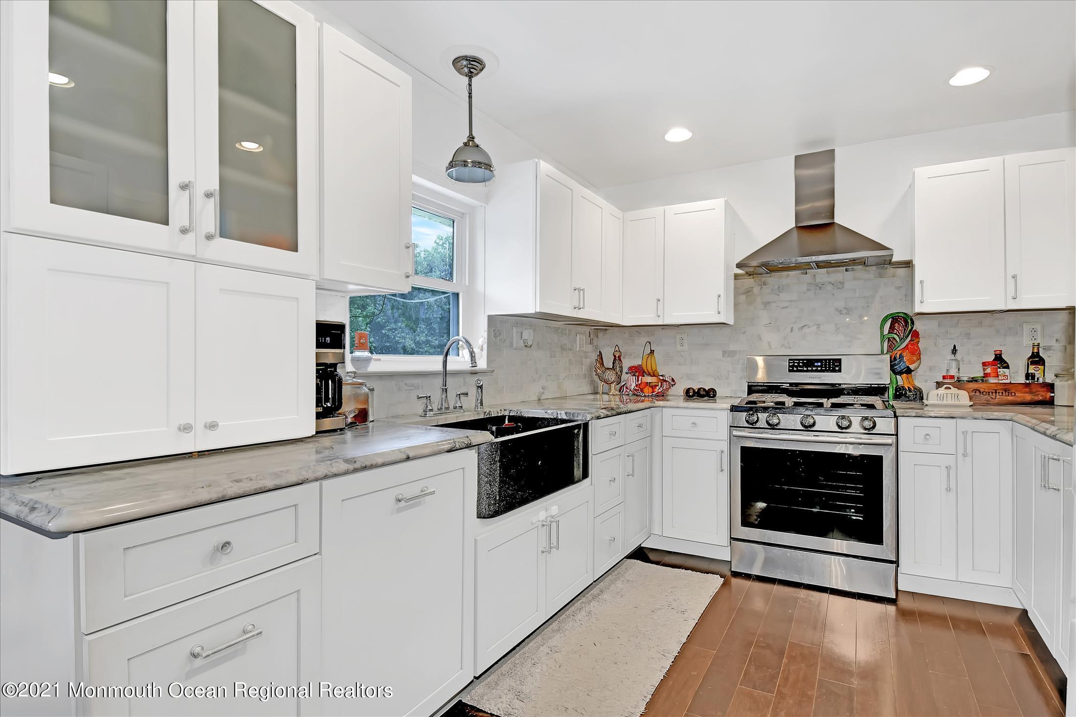 675 Harmony Road Middletown, NJ 07748 - Photo 3 of 25 a white kitchen with granite countertop stainless steel appliances a sink and cabinets