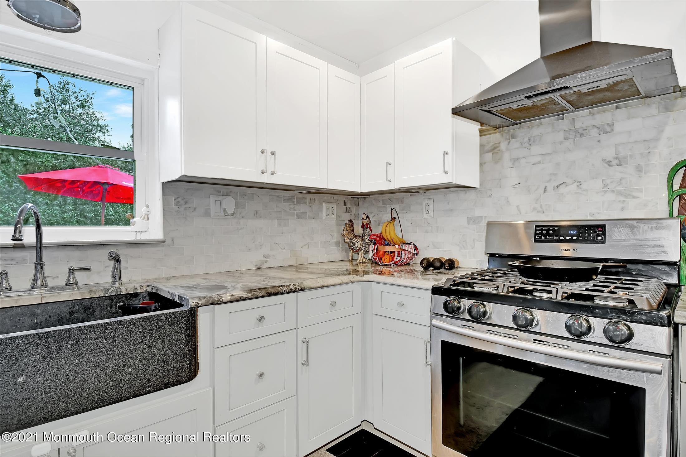 675 Harmony Road Middletown, NJ 07748 - Photo 4 of 25 a kitchen with stainless steel appliances granite countertop a stove a sink and a white cabinets