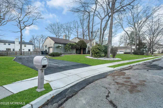 a front view of a house with garden and trees