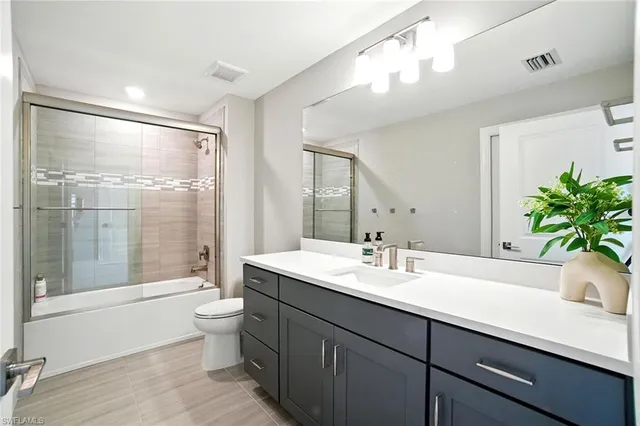 a bathroom with a double vanity sink toilet and shower
