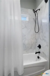 a bathroom with a bath tub with a shower