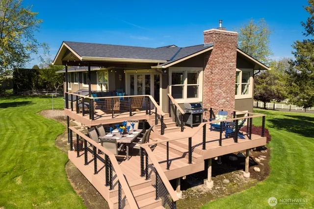 a view of a patio with table and chairs potted plants with wooden floor and fence