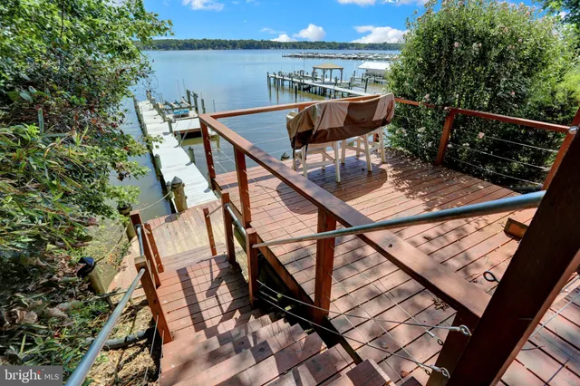 a kitchen with stainless steel appliances granite countertop a refrigerator a sink dishwasher a stove and a refrigerator with wooden floor