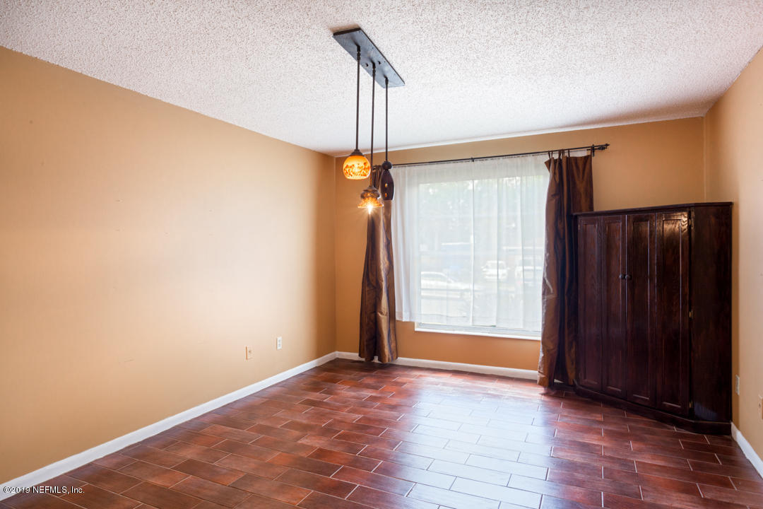 8759 Moss Haven Road Jacksonville, FL 32221 - Photo 13 of 29 an empty room with wooden floor and windows