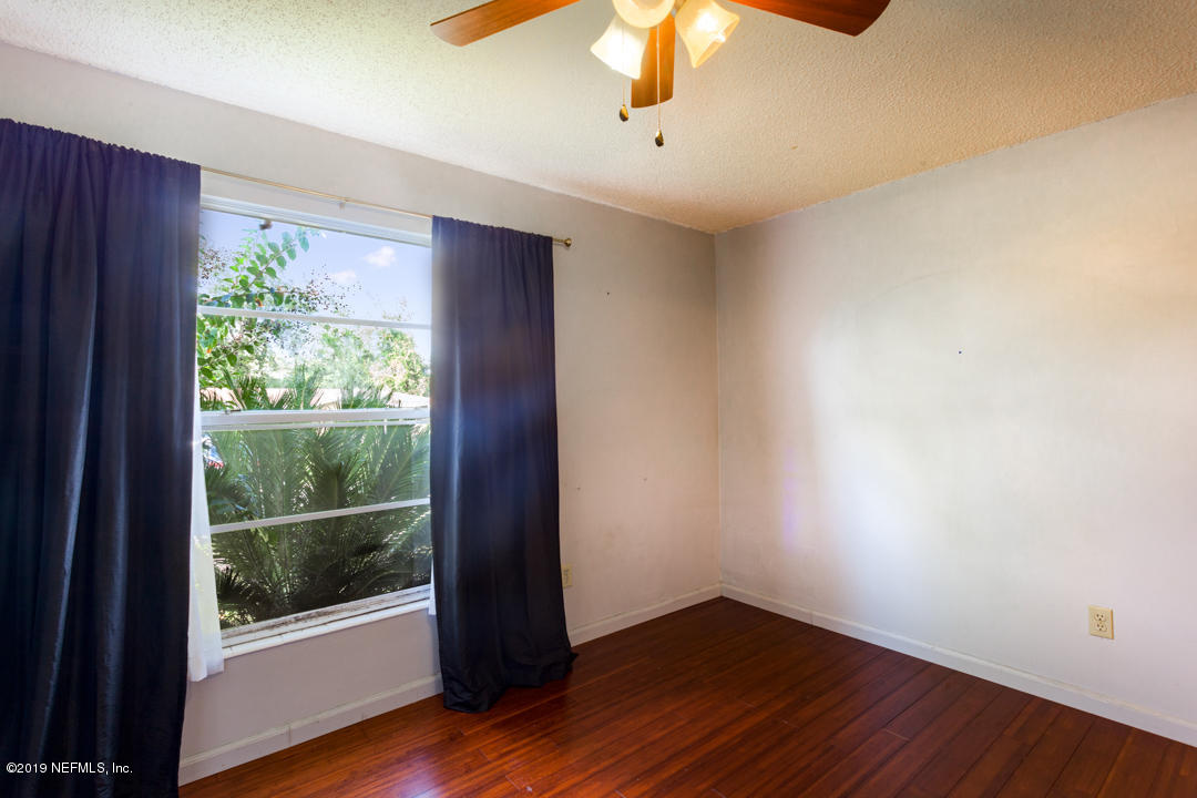 8759 Moss Haven Road Jacksonville, FL 32221 - Photo 22 of 29 an empty room with wooden floor and windows