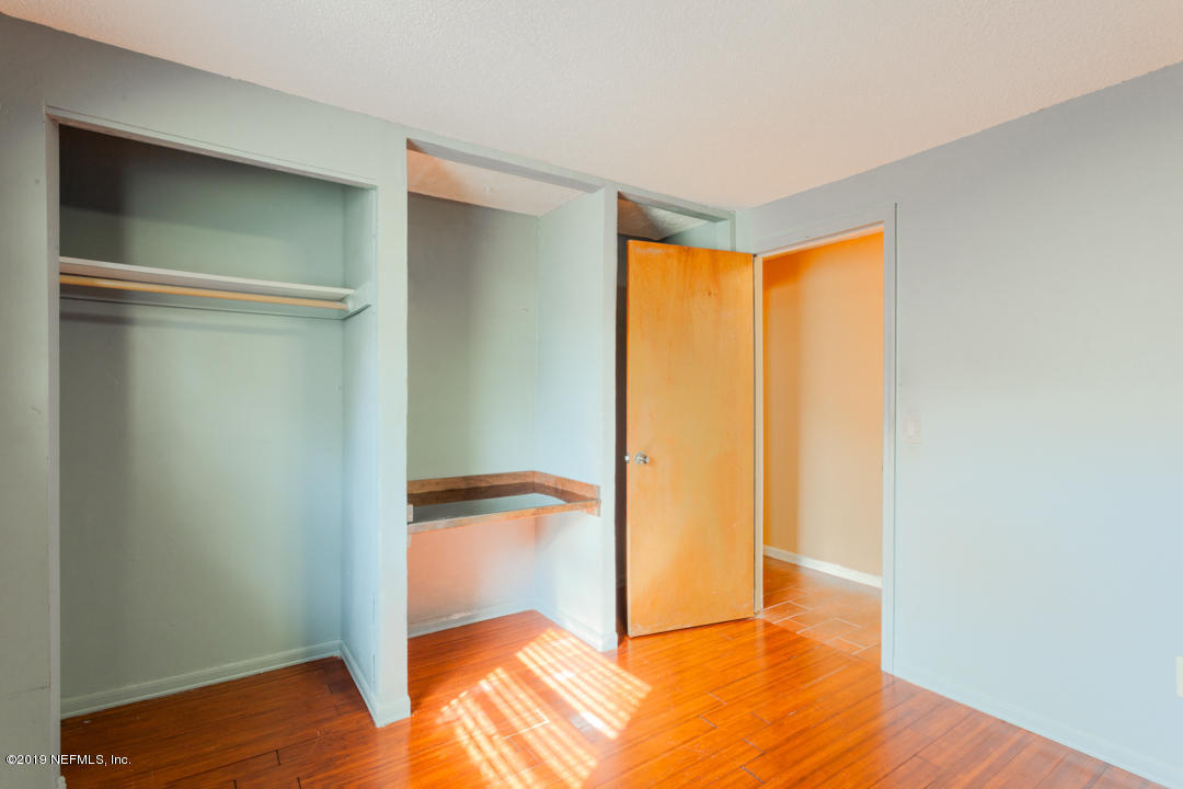 8759 Moss Haven Road Jacksonville, FL 32221 - Photo 24 of 29 a view of an empty room with wooden floor and a closet