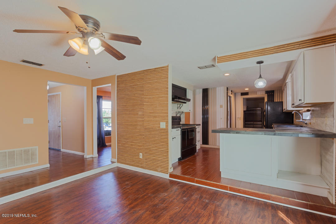 8759 Moss Haven Road Jacksonville, FL 32221 - Photo 4 of 29 a view of a kitchen with a refrigerator wooden floor and a ceiling fan