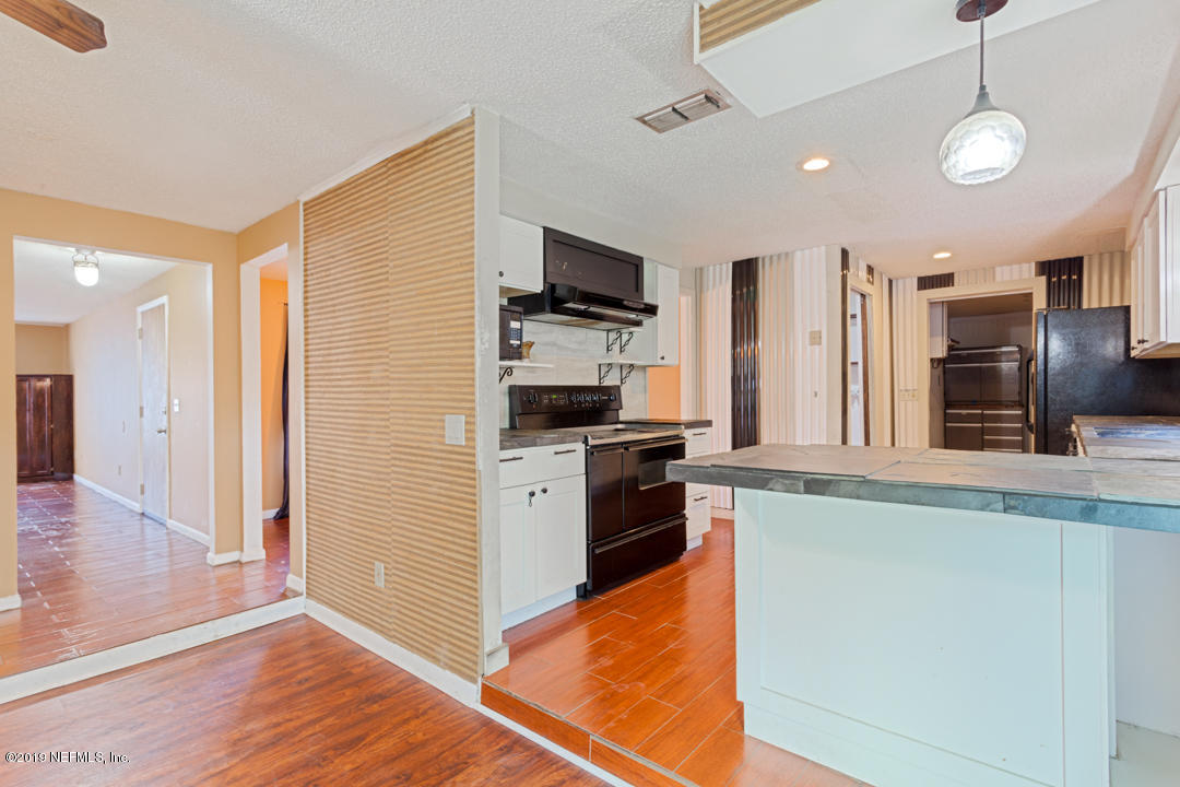 8759 Moss Haven Road Jacksonville, FL 32221 - Photo 9 of 29 a kitchen with stainless steel appliances granite countertop a refrigerator and a stove top oven