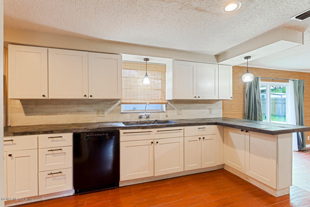8759 Moss Haven Road Jacksonville, FL 32221 - Photo 10 of 29 a kitchen with granite countertop a sink and cabinets