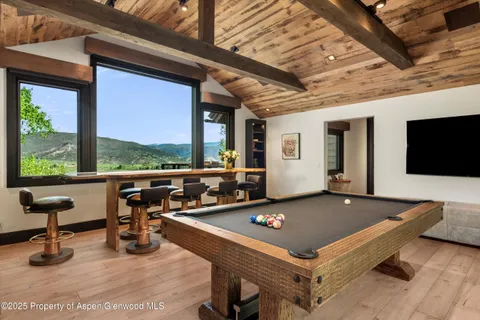 a living room with furniture pool table and a large window