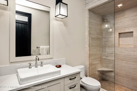 a bathroom with a sink toilet vanity and shower