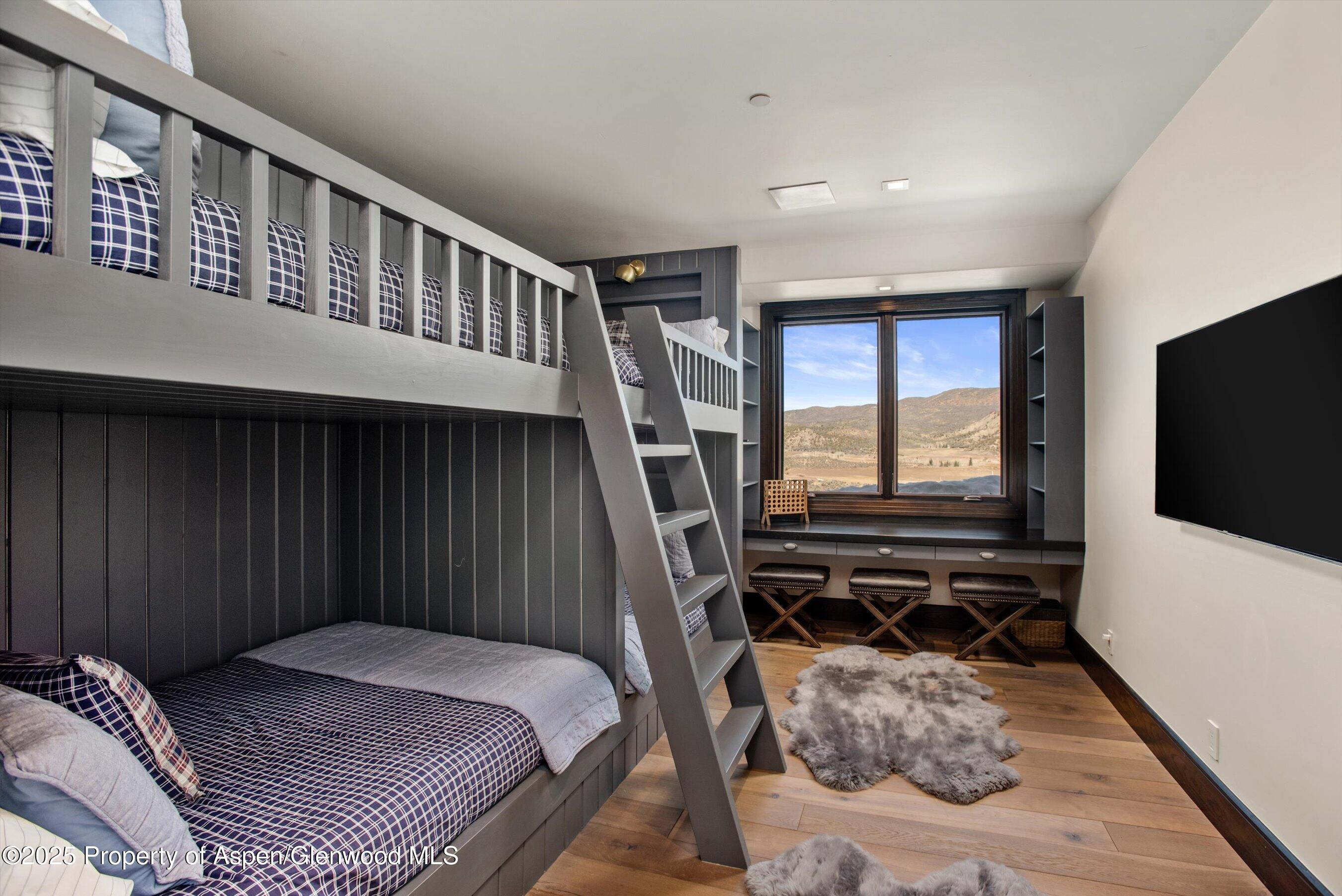 2318 Lazy O Road Snowmass, CO 81654 - Photo 23 of 50 a bedroom with a bed and a flat tv screen on the dresser