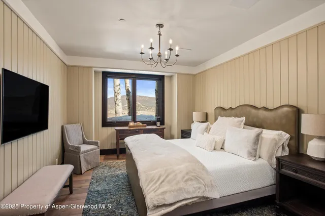 a spacious bedroom with a bed and a flat screen tv