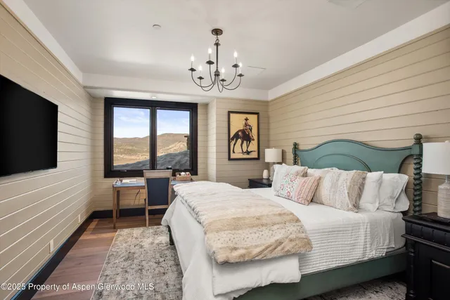 a bedroom with bed tv and window