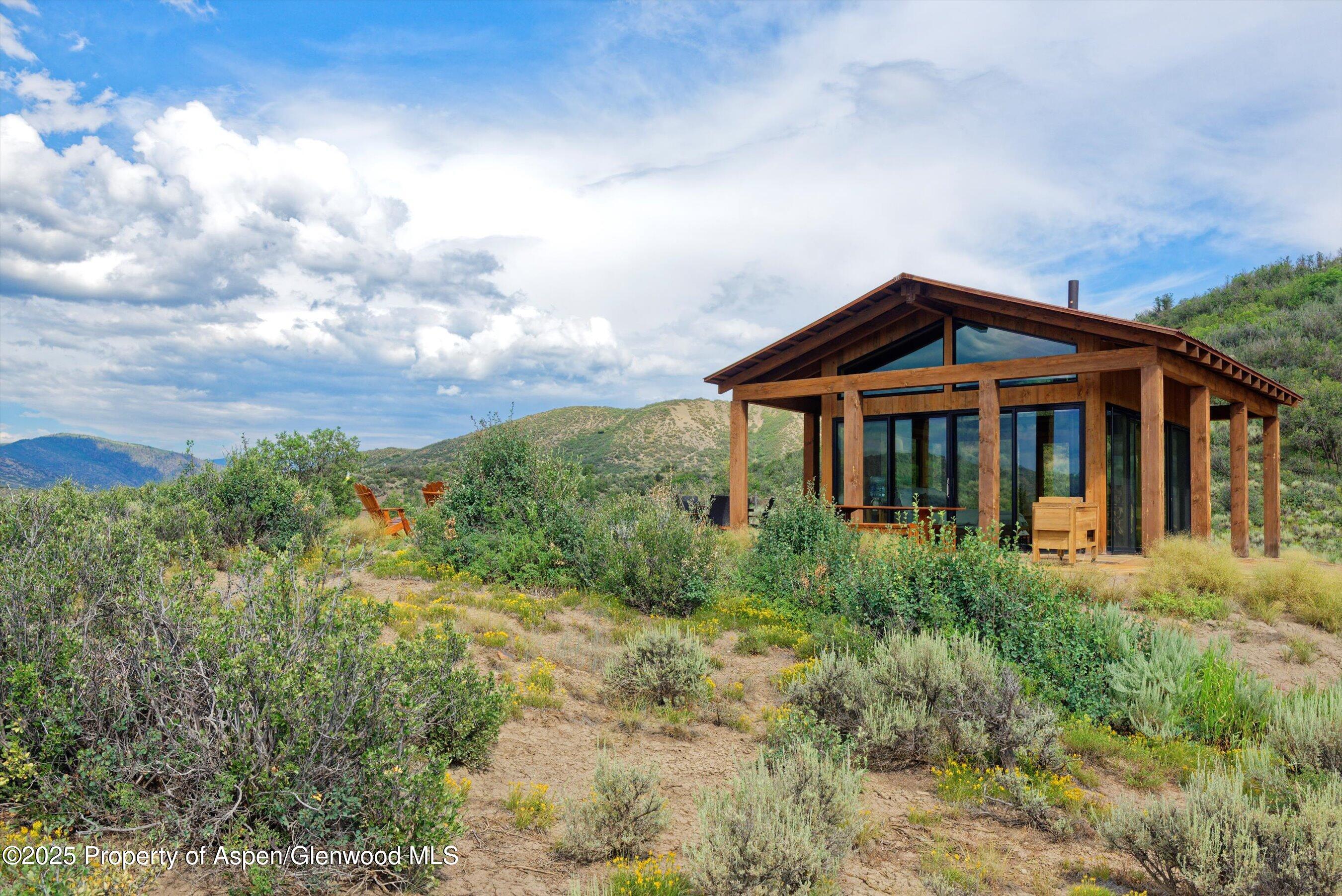 2318 Lazy O Road Snowmass, CO 81654 - Photo 42 of 50 a front view of a house with a yard