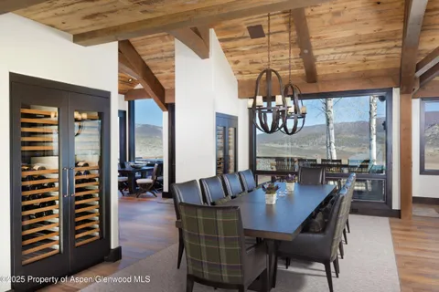 a dining room with furniture a chandelier and window