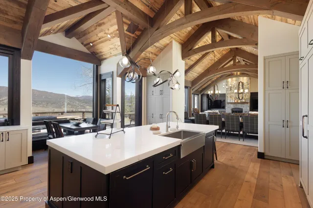 a kitchen with a sink a counter top space a large window and furniture