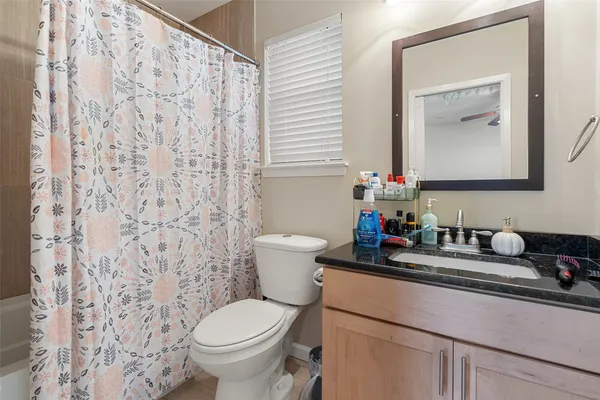 a bathroom with a granite countertop toilet a sink and a mirror