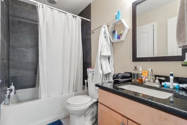a bathroom with a sink a toilet and shower curtain