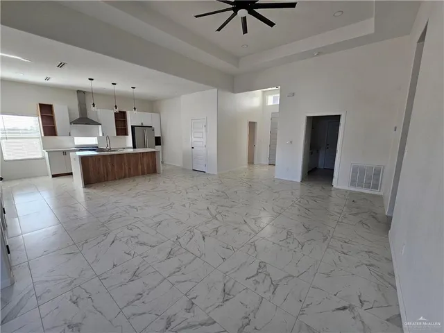 a view of a hallway with kitchen and chandelier