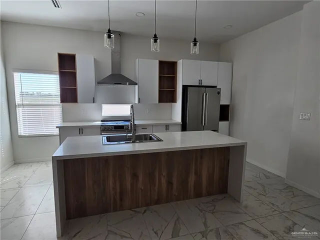 a kitchen with stainless steel appliances a sink stove and refrigerator