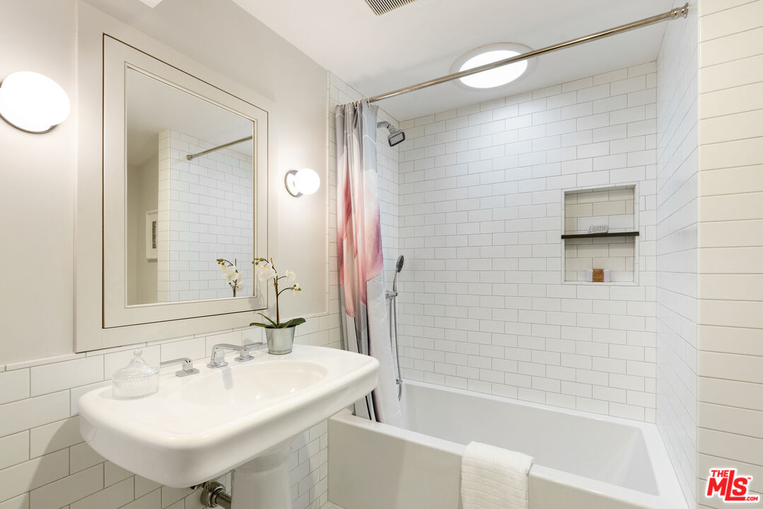 1104 Acanto Place Los Angeles, CA 90049 - Photo 21 of 39 a bathroom with a sink a shower and a mirror