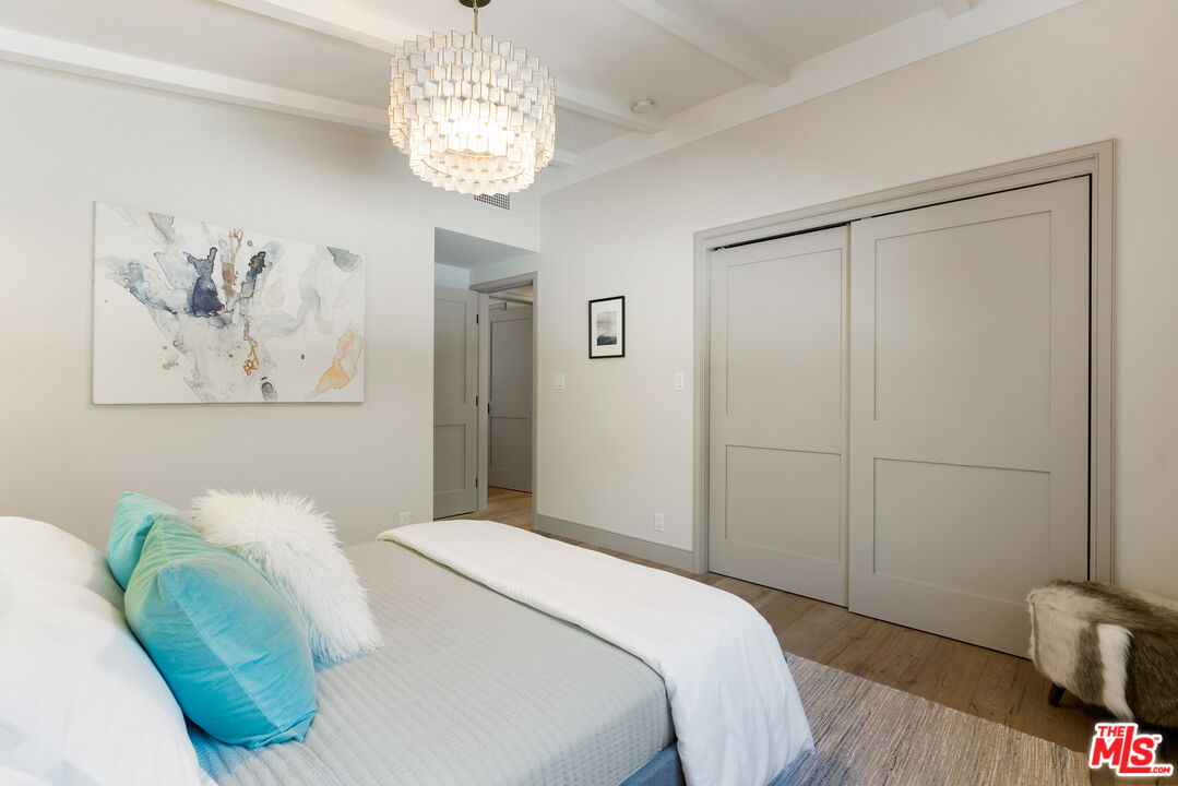 1104 Acanto Place Los Angeles, CA 90049 - Photo 23 of 39 a bedroom with a bed and a chandelier