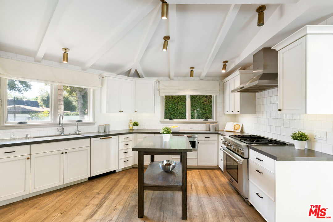 1104 Acanto Place Los Angeles, CA 90049 - Photo 6 of 39 a kitchen with granite countertop a sink stove cabinets and wooden floor
