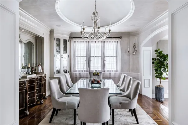 a kitchen with granite countertop a stove a sink a dining table and chairs