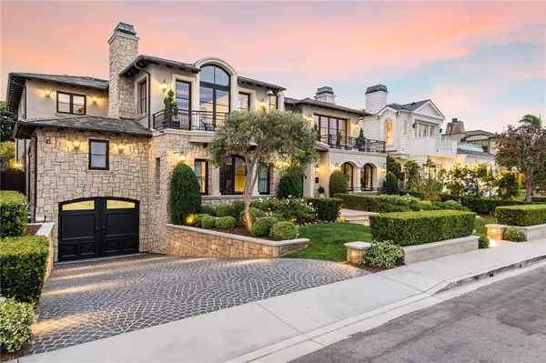 a front view of a house with a yard and potted plants