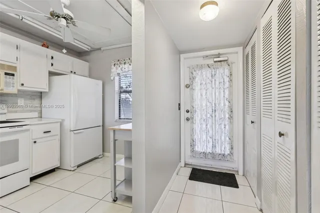 a white refrigerator freezer and a stove sitting inside of a kitchen