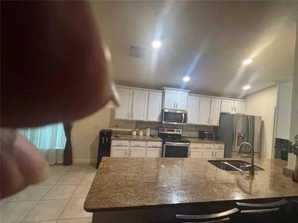 a kitchen with stainless steel appliances granite countertop a sink a stove and a refrigerator