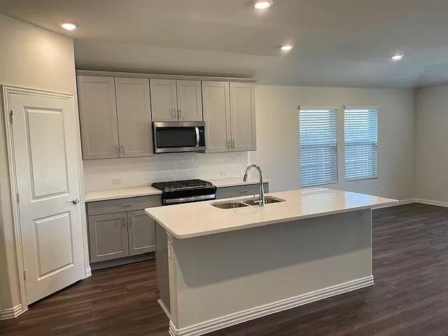 3008 Kingsgarden Road Denton, TX 76207 - Photo 2 of 9 a kitchen with granite countertop a sink and a stove top oven