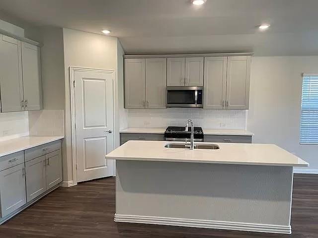 3008 Kingsgarden Road Denton, TX 76207 - Photo 3 of 9 a kitchen with kitchen island a sink a stove and a refrigerator